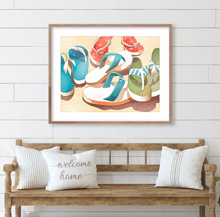 Pair of flip flops left in the sand at the beach, coastal art print displayed in a light beach house interior