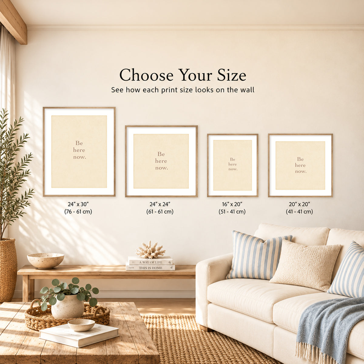 Coastal living room showing four framed ‘Be here now.’ art prints in different sizes, labeled 24x30, 24x24, 16x20, and 20x20 inches.